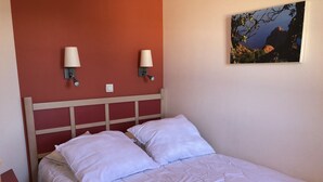A bed with white bedding and two wall-mounted lamps. - Cap Esterel Agay - large garden - exceptional sea and pool views (Saint-Raphaël)