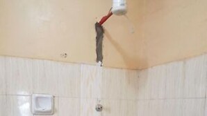 A bathroom with white tiled walls and a shower area. - Kapsabet Comfy Hotel (Kapsabet)