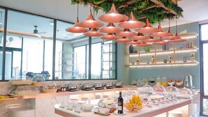 A breakfast buffet with various food items and a wine bottle, surrounded by glass display cases and a modern interior design. - Infinity Aonang Krabi Hotel (Krabi)