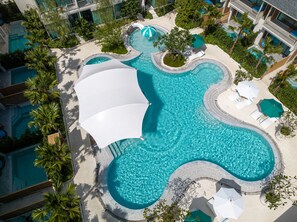 An aerial view of a resort with multiple swimming pools, palm trees, and lounge areas. - Infinity Aonang Krabi Hotel (Krabi)