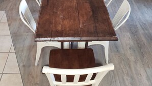 A rectangular wooden dining table with white chairs.
