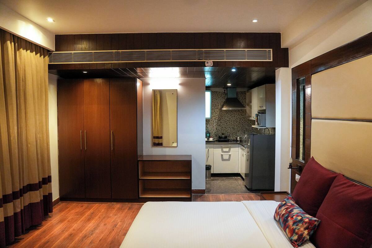 Habitación de hotel con cama, armario, kitchenette y baño.