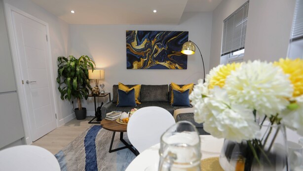 Un salon moderne avec un canapé, une table basse et un tableau accroché au mur.