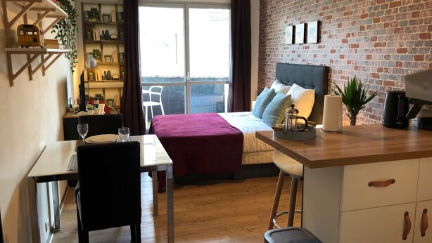 A cozy room with a bed, a desk, a chair, a coffee maker, and a view of the outdoors. - Studio with balcony & free parking (Tours)