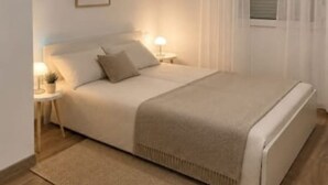 A bedroom with a bed, bedside tables, a lamp, and a window with curtains. - Apartments Melita (Zadar)