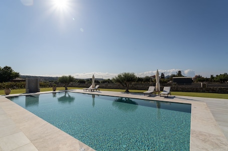 Una piscina al aire libre, sombrillas