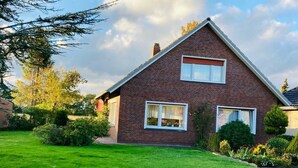 A two-story house with a brick exterior, a well-maintained lawn, and a clear sky. - Vacation apartment Berta 25508 - Holiday apartment Berta, 25508 (Weener)