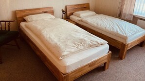 Two wooden beds with white linens in a room with beige walls and a window with curtains. - Vacation apartment Berta 25508 - Holiday apartment Berta, 25508 (Weener)