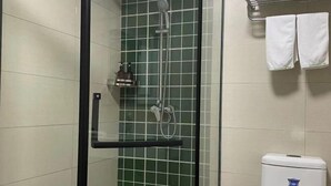 Een douche met glazen deur, een handdoekhouder met twee handdoeken en een toilet met een blauw logo.