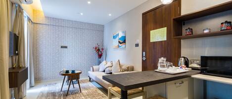 A modern kitchen with a dining area, a sofa, and a coffee table.