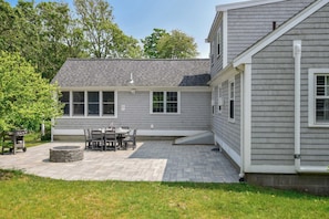 A house with a patio, a fire pit, and a dining area.