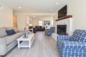 A living room with a sofa, armchair, and a fireplace.