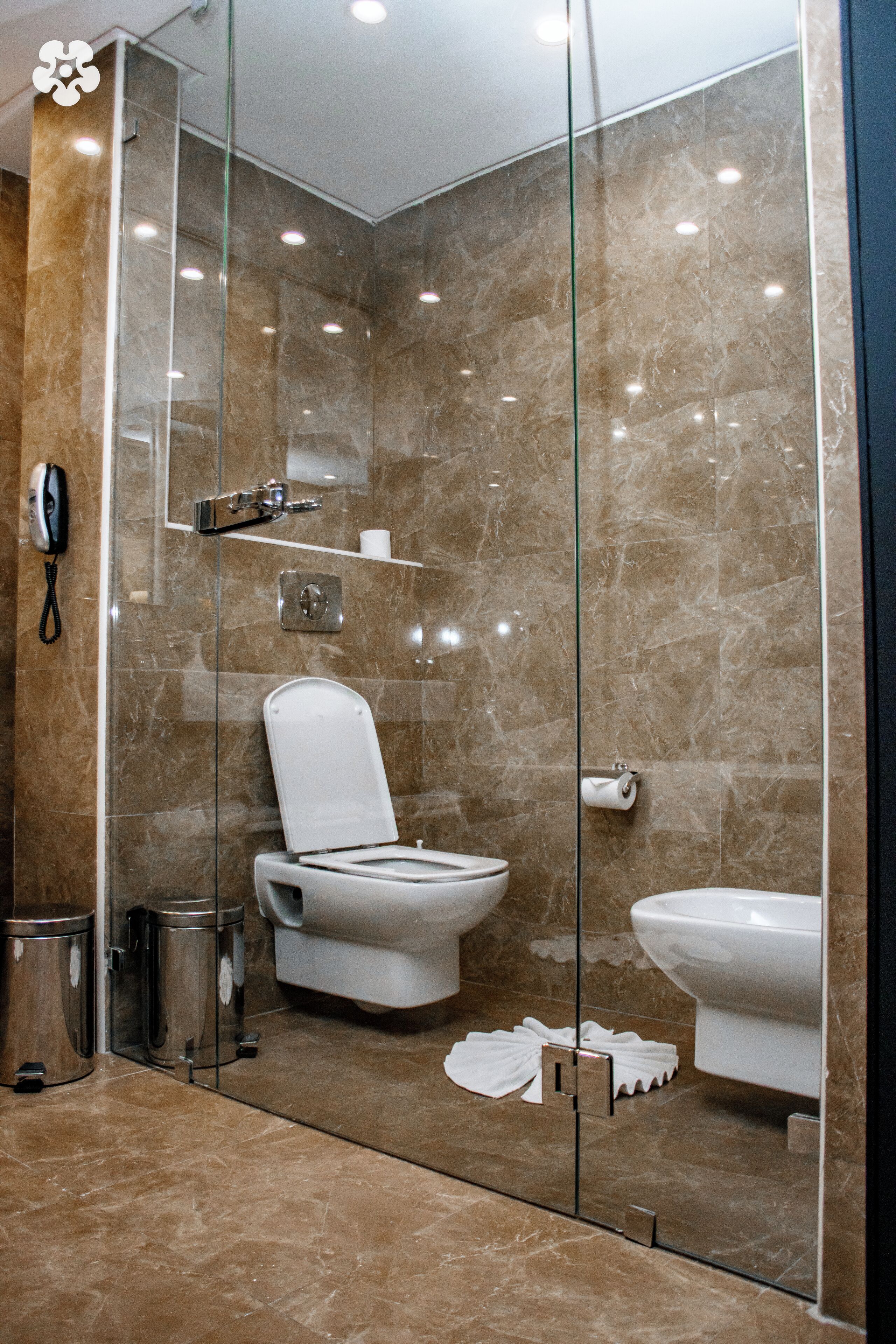 Un baño moderno con ducha de vidrio, inodoro y bidé.