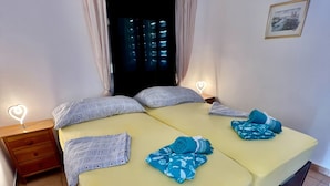 A double bed with patterned pillows, a bedside table with a heart-shaped light, and a nightstand with a drawer. - Holiday Apartment "WG1 Benidorm" Near the Beach with Sea View, Balcony, Air Conditioning and Wi-Fi (Benidorm)