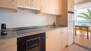 A kitchen with granite countertops, stainless steel appliances, and wooden cabinets. - Holiday Apartment "WG1 Benidorm" Near the Beach with Sea View, Balcony, Air Conditioning and Wi-Fi (Benidorm)