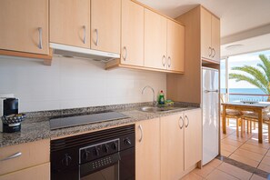 Eine Küche mit Granit Arbeitsplatten, Edelstahlgeräten und Holzschränken.