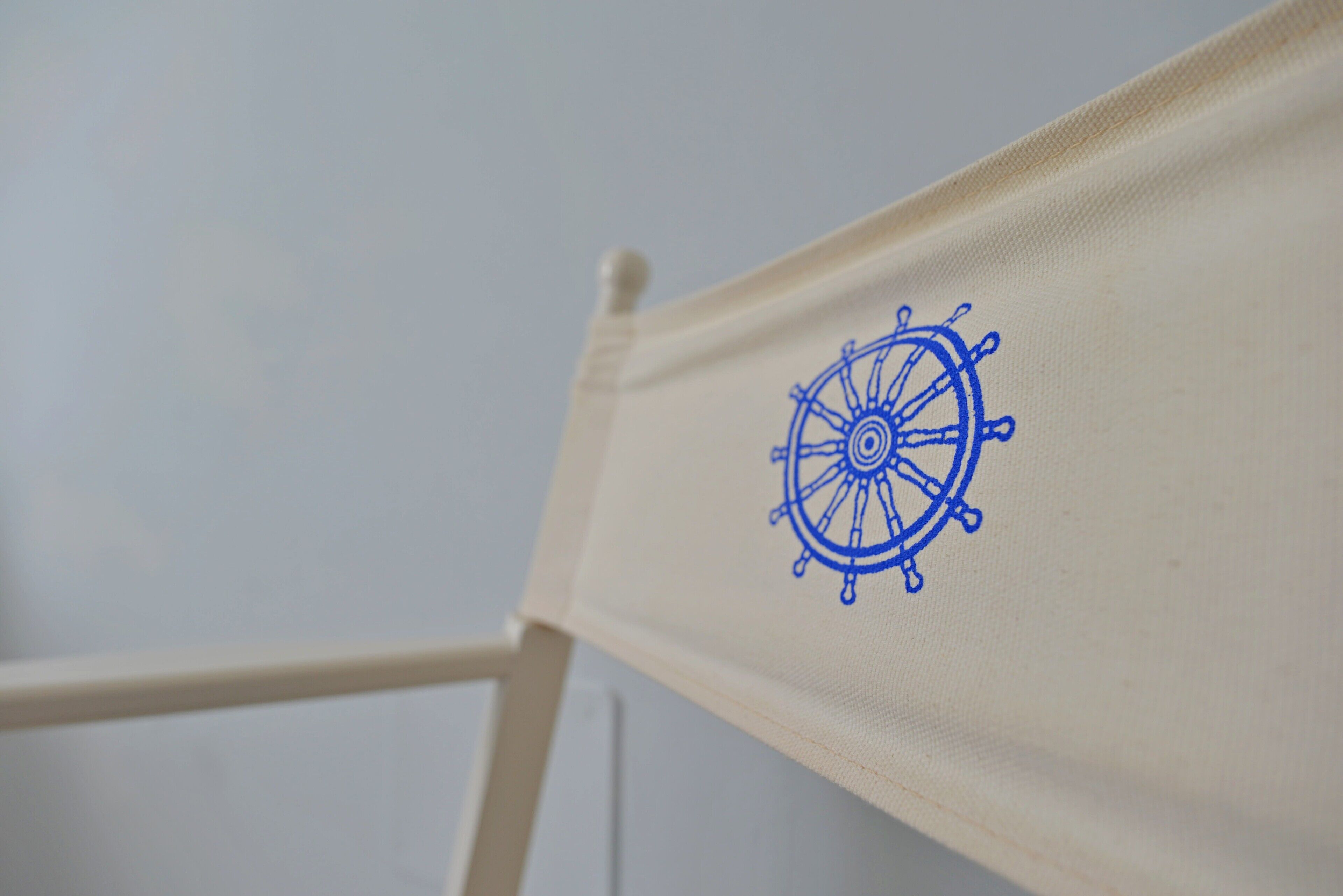 A close-up of a chair with a blue wheel design on the fabric.
