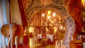 An interior with a unique architectural design, including a large archway and decorative elements. - Chui Lodge (Naivasha)