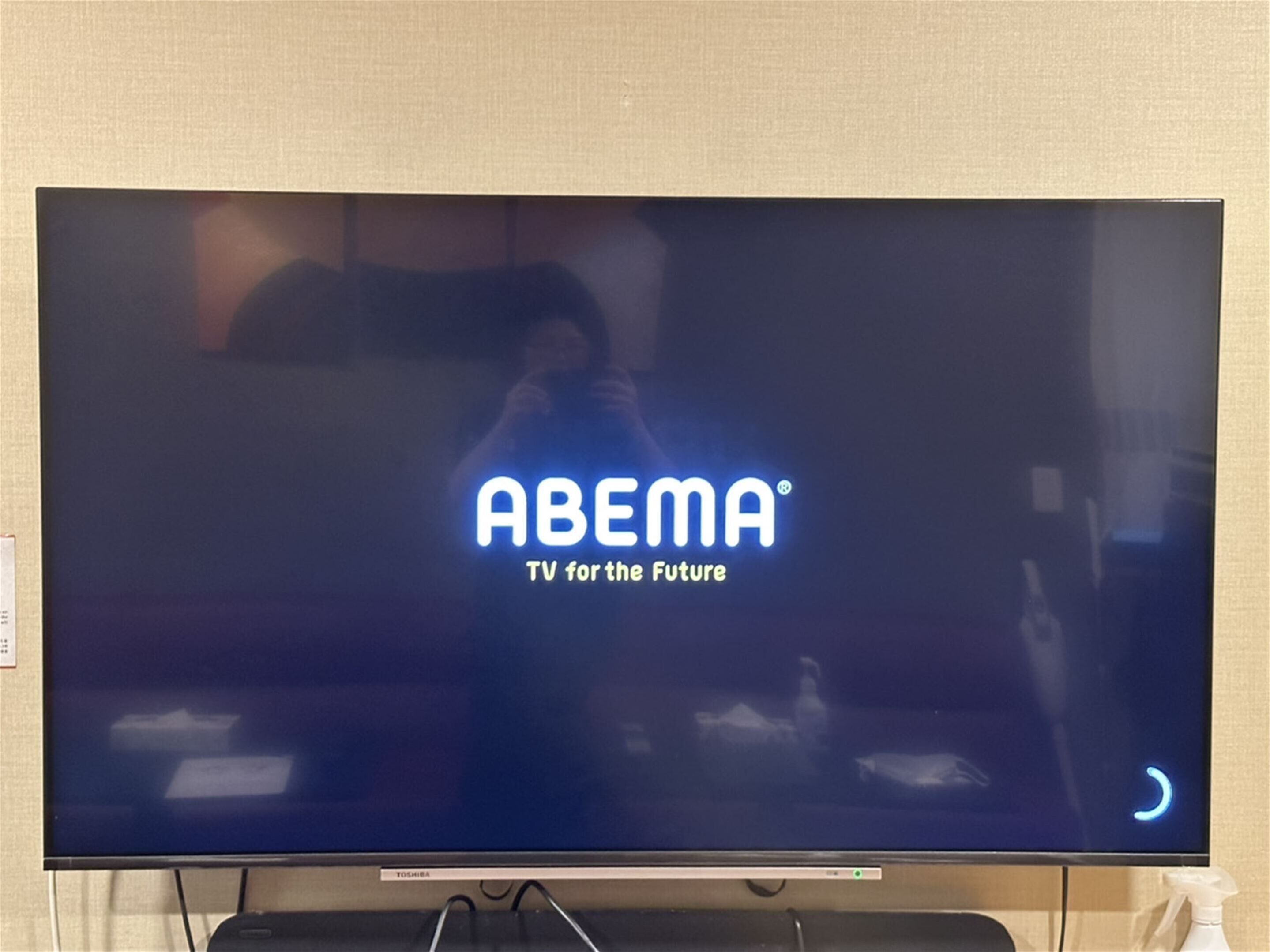 Et fladskærms-tv, der viser ABEMA's logo og slogan.