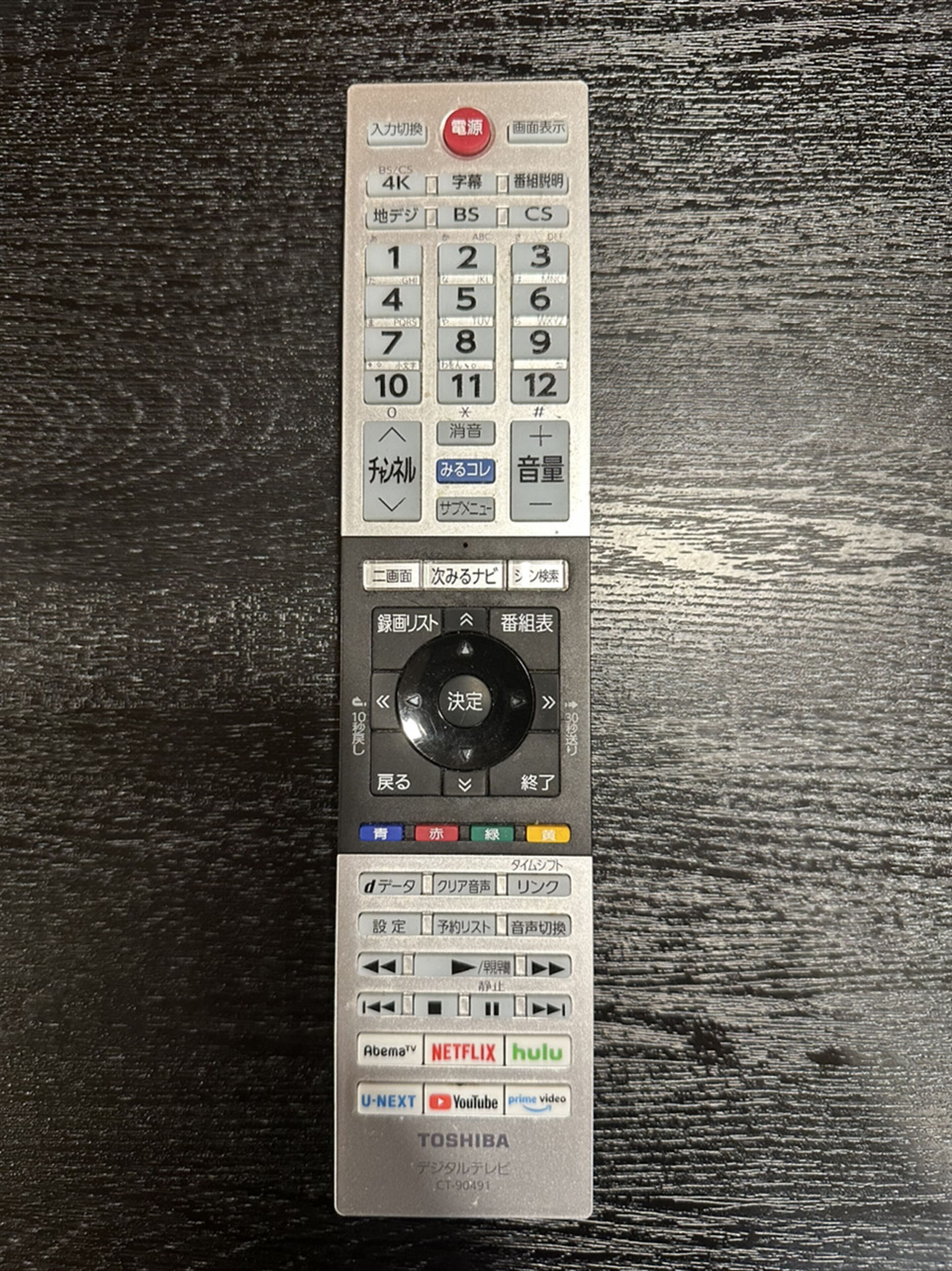 Une télécommande Toshiba dotée de nombreux boutons et d’un pavé numérique.