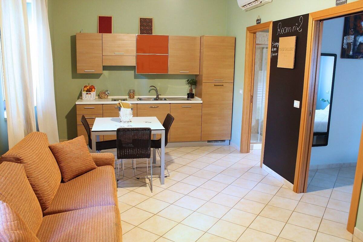 A compact living space with a kitchenette, a dining area, and a small sofa.