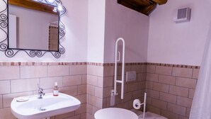 Une salle de bain avec un lavabo, des toilettes et une petite table.
