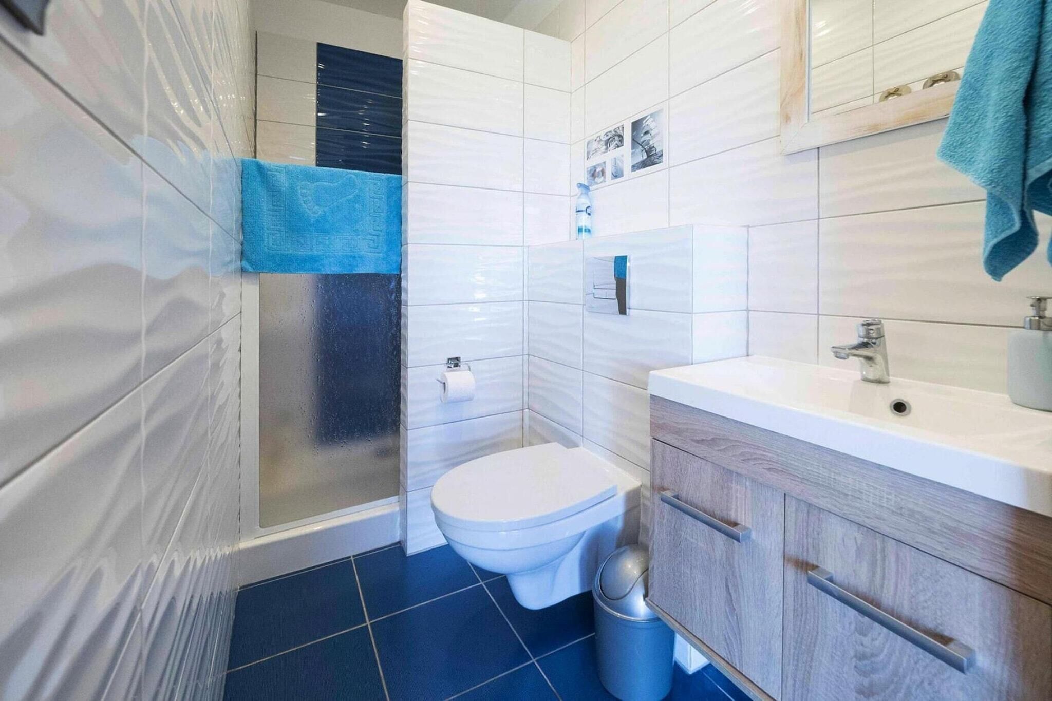 Een moderne badkamer met een wit toilet, een wastafel en een spiegel.