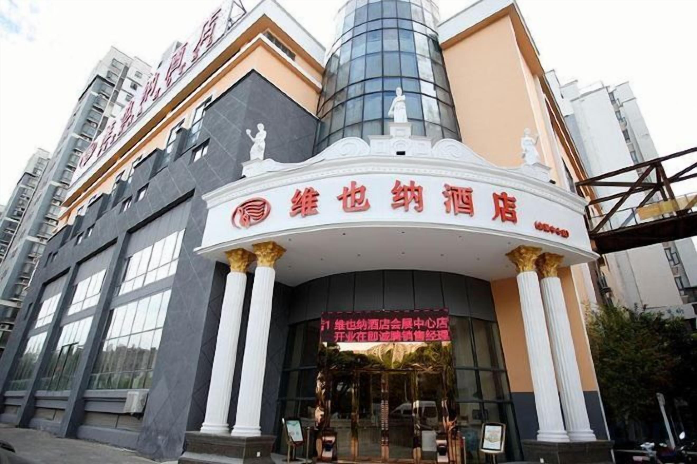 A building with a prominent entrance, columns, and a sign with Chinese characters.