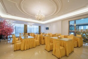 A conference room with round tables and chairs, a chandelier, and large windows. - Vienna Hotel (Kunshan Convention and Exhibition Center) (Kunshan)