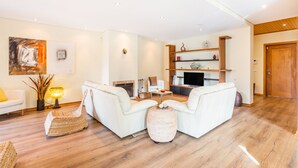 A modern living room with a fireplace, white sofas, and a television. - Furadouro Sunny Family Villa (Ovar)