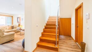 A staircase with wooden steps and a metal handrail leading to a wooden door. - Furadouro Sunny Family Villa (Ovar)