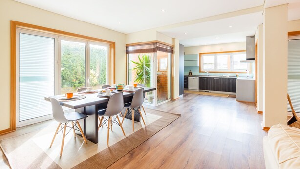 A modern kitchen with a dining area, large windows, and a view of greenery. - Furadouro Sunny Family Villa (Ovar)