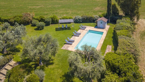An aerial view of a property with a swimming pool, lounge chairs, a small shed, and surrounding greenery. - Chalet Vignarola (Orbetello)