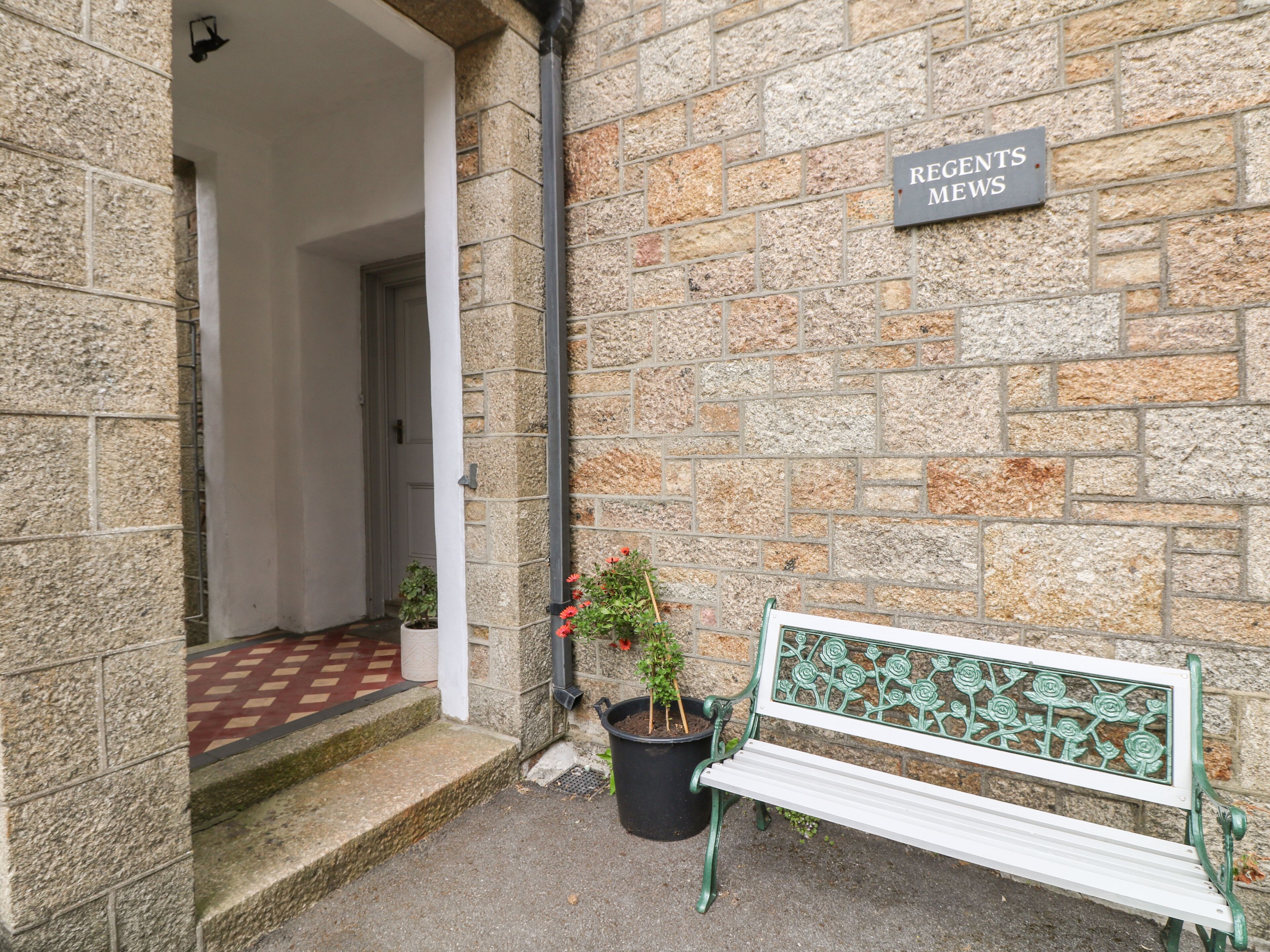 A stone building with a bench and a sign reading "REGENTS NEWS".