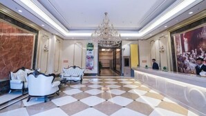 A hotel lobby with a checkered floor, a chandelier, and a reception desk. - Vienna Hotel (Jiangmen Wanda Plaza Store) (Jiangmen)