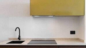 A modern kitchen with a black sink, a black countertop, and a yellow cabinet above. - Apartment Biancolilla - Maina Country Resort - with pool, in Sicily (Naso)