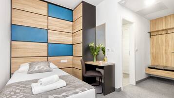 Ein modernes Hotelzimmer mit Bett, Schreibtisch und Sitzecke.