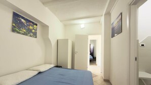 Une chambre à coucher avec un lit, une armoire et un tableau accroché au mur.