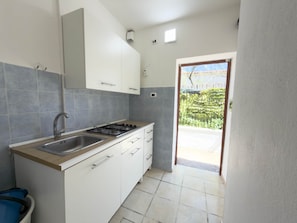 A kitchen with white cabinets, a stainless steel sink, and a gas stove.