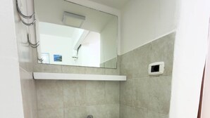 A bathroom with a white sink, a mirror above it, and a small window. - Villa Maica 8, Palinuro, Cilento (Palinuro)