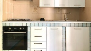 A kitchen with white cabinets, a stove, an oven, and a sink. - Villa Arco 1, Palinuro, Cilento (Palinuro)
