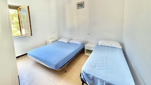 A room with two single beds, a small bedside table, a window with a view of trees, and a light fixture. - Villa Arco 7, Palinuro, Cilento (Palinuro)