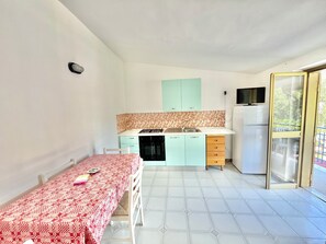 Réfrigérateur, un four, surface de cuisson, vaisselle et ustensiles