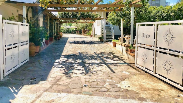A stone-paved courtyard with a pergola covered in climbing plants, white gates labeled "Villa" and "Arco", and a staircase leading to a building. - Villa Arco 2, Palinuro, Cilento (Palinuro)
