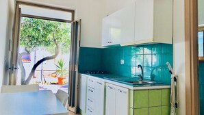 A compact kitchen with a sink, cabinets, and a dining area. - Villa Arco 9, Palinuro, Cilento (Palinuro)