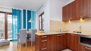 Eine moderne Küche mit Holzausstattung, einem eingebauten Backofen und einem Essbereich mit Tisch und Stühlen.