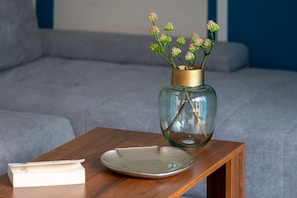 A clear view of a room with a wooden side table, a vase with flowers, and a book.