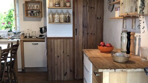 Eine Küche mit Holzböden, einer Holzinsel und einem Fenster mit Blick auf Grünflächen.