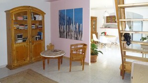 A room with a wooden cabinet, a table with chairs, a painting, and a view into another room. - My Guitoune (ST REMY DE PROVENCE)