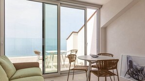 A balcony with a glass door, a round table with chairs, and a green sofa. - Apartment Ogliarola - Maina Country Resort - with pool, in Sicily (Cresta)